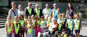 Stadt Marl und Dekra übergeben die Sicherheitskragen an die Kinder.
