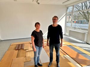 Das Bild zeigt die Künstlerin Stefanie Klingemann gemeinsam mit Museumsdirektor Georg Elben stehend auf der entstehenden Skulptur aus gespendetem Altmobiliar.
