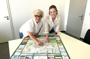 Sozialdezernentin Claudia Schwidrik-Grebe (links) und Jugendhilfeplanerin Anna Timmerhaus erläutern auf dem Stadtplan, wo neue Kitas entstehen sollen. Foto: Stadt Marl / Pressestelle