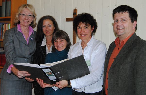 Europaabgeordnete Jutta Haug, Sozialdezernentin Dr. Barbara Duka, Diplom Sozialpädagogin Ramona Glodschei, Diplompädagogin Elisabeth Albers und Pfarrer Jörg Krunke (v.l.) bei der Durchsicht des Evaluations-Ordners/interessiert an der jährlichen Dokume