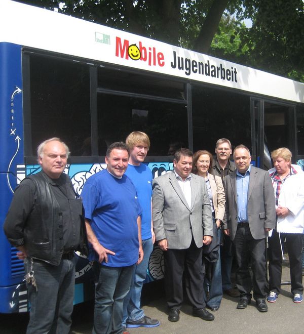 Die beiden Streetworker Ömer Cerit und Martin Weijers freuen sich mit prominenten Gästen über den neuen Bus für die mobile Jugendarbeit.